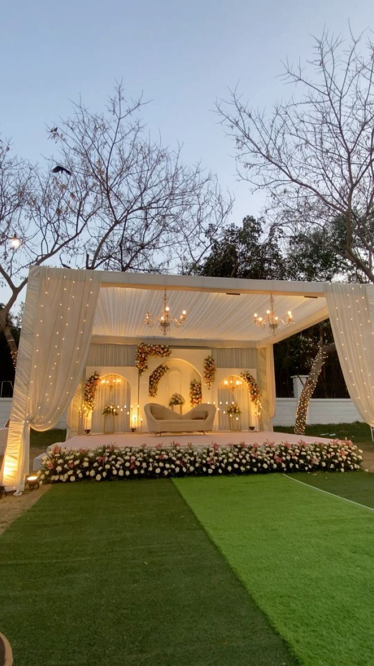 Elegant ivory wedding reception mandap with fairy lights and floral arch